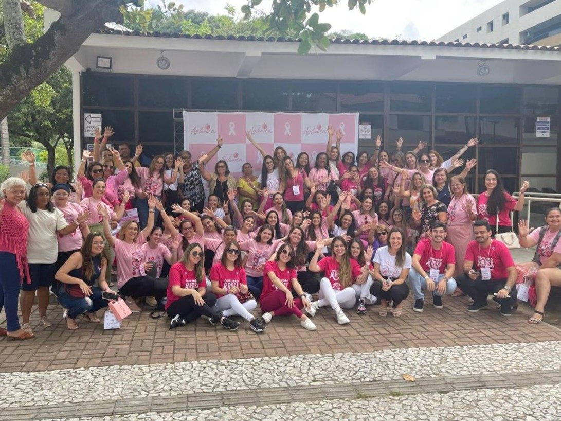 Grupo de participantes com camisetas rosa em evento do Outubro Rosa do Projeto Aghata
