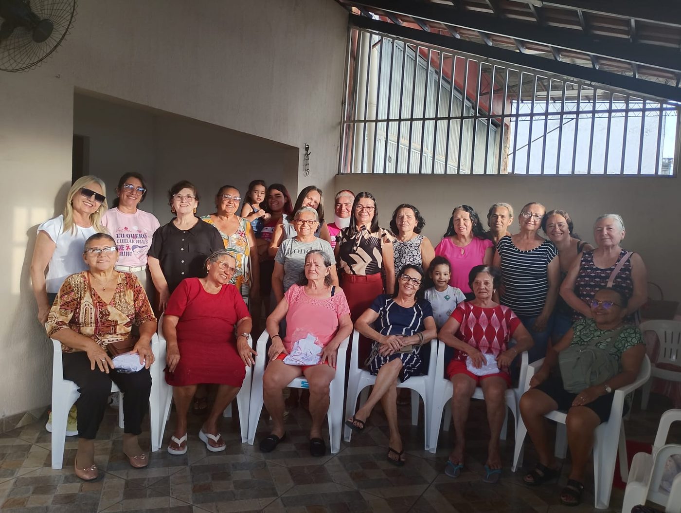 Encontro com mulheres da comunidade, sentadas e em pé, em uma roda de conversa