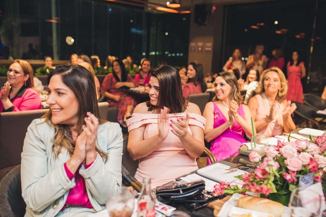 Convidadas aplaudindo em jantar beneficente do Projeto Aghata